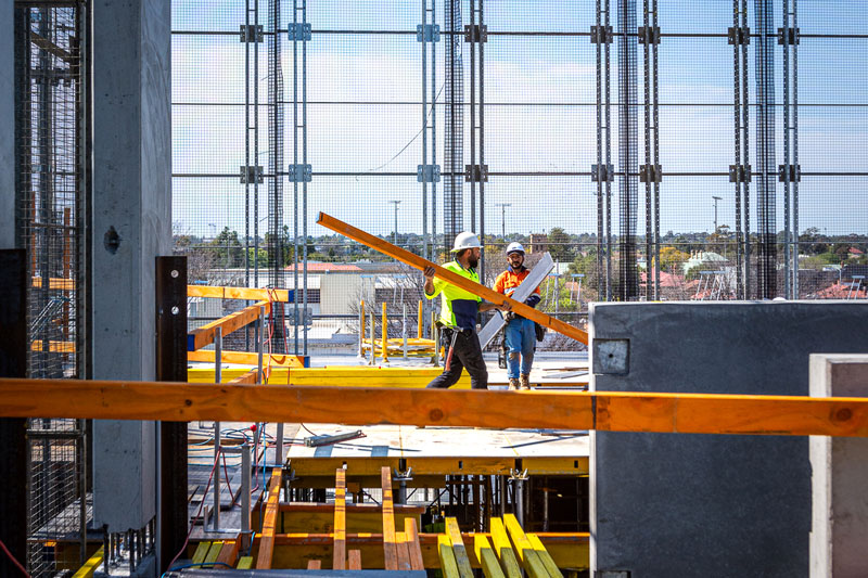 working carrying a wooden beam